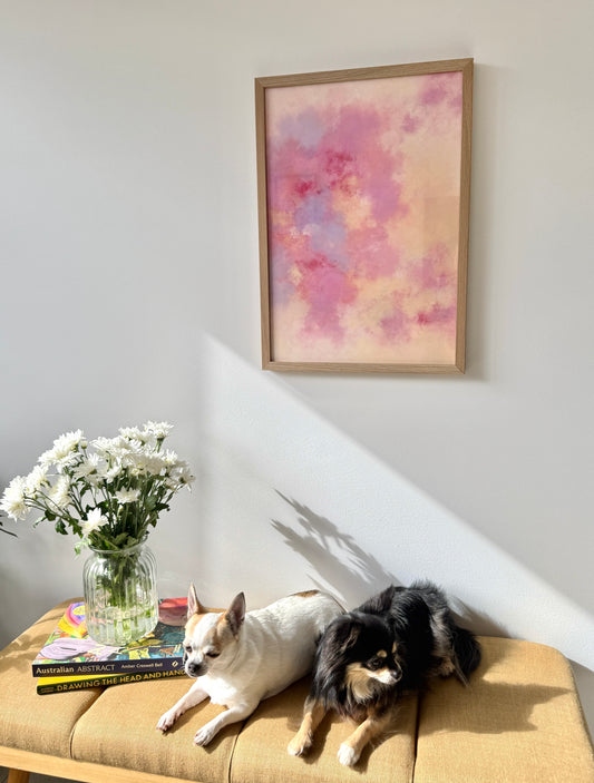 Lucent is a luminous, dreamlike landscape filled with soft light and gentle movement. Layers of yellow and white create a glowing backdrop, while delicate touches of mauve-blue and fading pinks drift across the surface. Hints of red melt into pink, offering moments of subtle detail throughout this atmospheric, abstract piece. Calm, floaty, and full of warmth — it invites quiet reflection and a sense of peace.